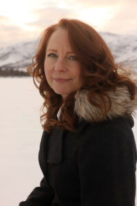 Woman in winter coat with snowy mountain in background